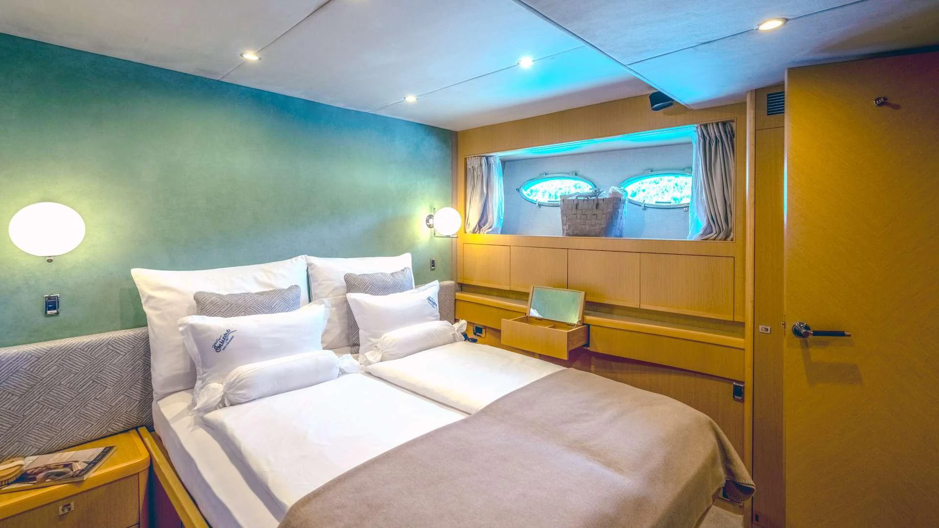 a room with a bed and a television aboard INSIEME Yacht for Charter