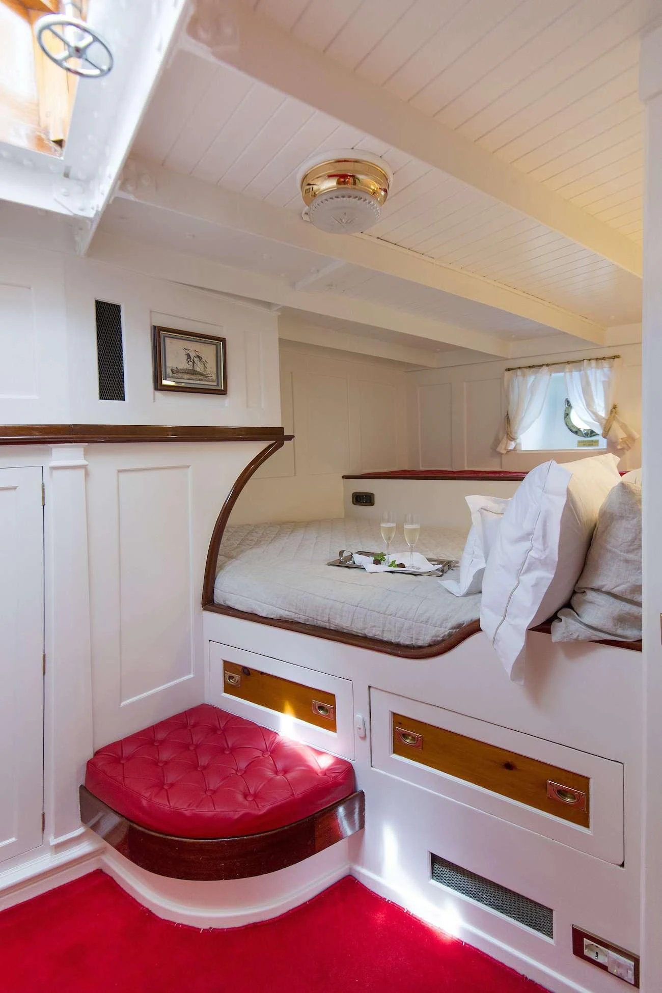 a bedroom with a red rug aboard PURITAN Yacht for Charter