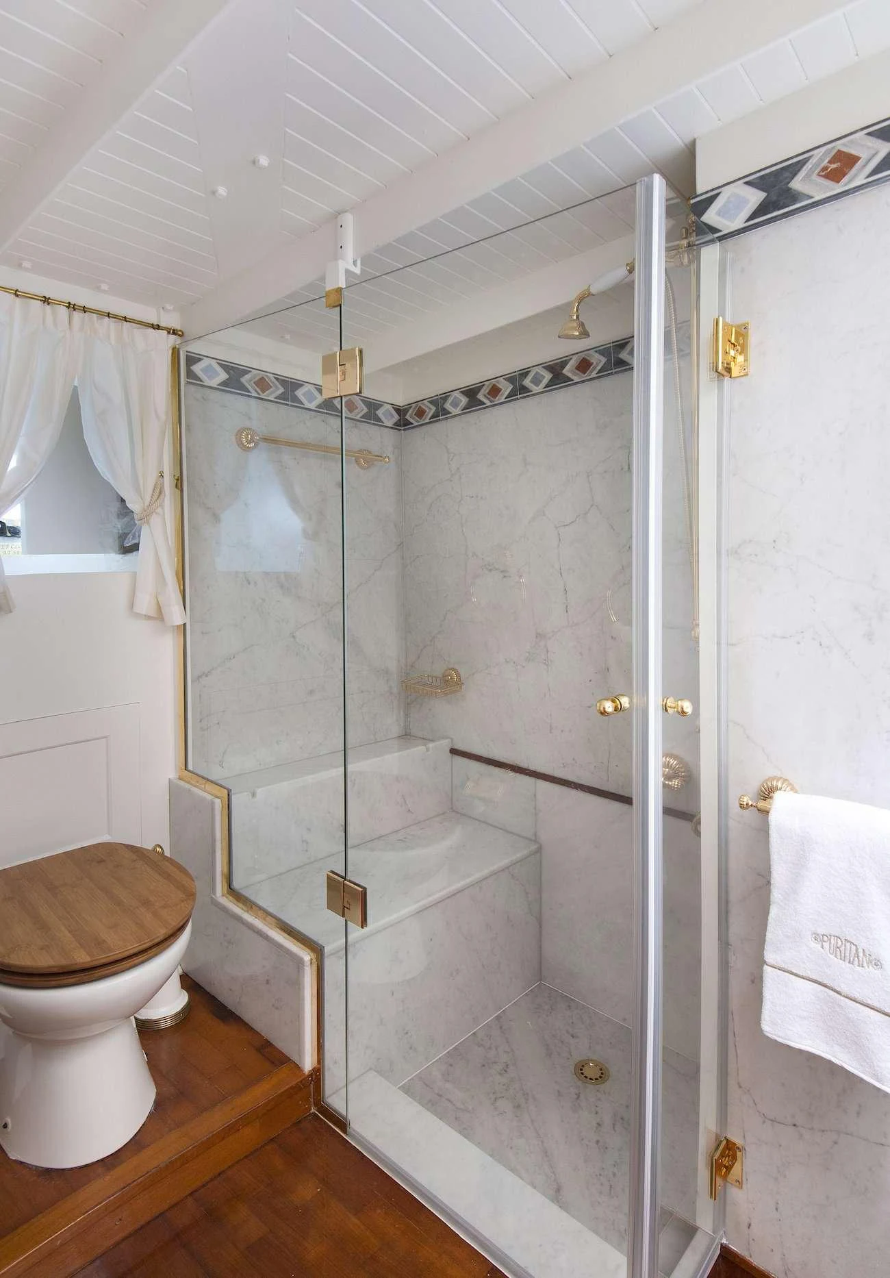 a bathroom with a shower unit and toilet aboard PURITAN Yacht for Charter