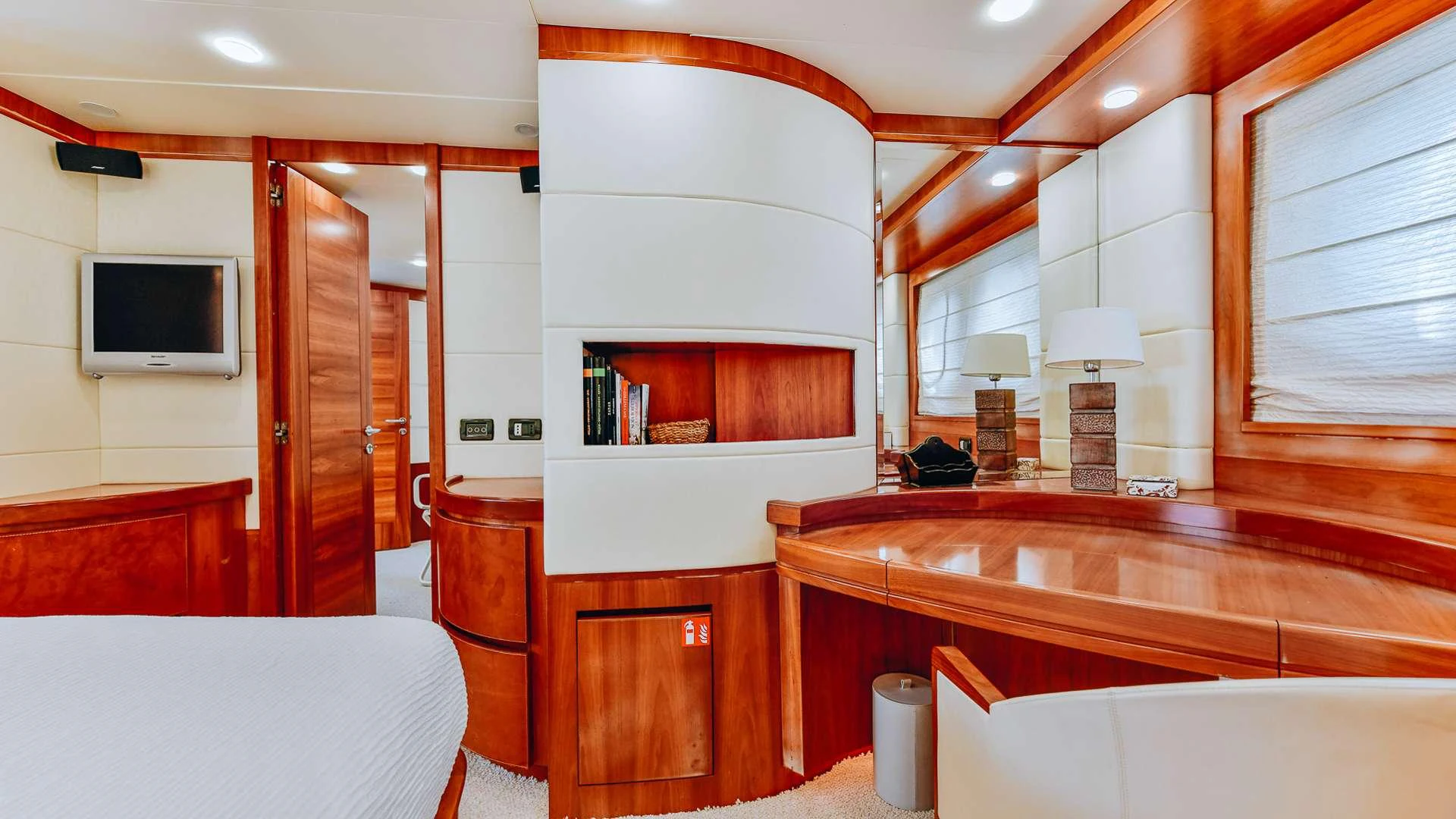 a room with a bed and a television aboard CAMY Yacht for Charter