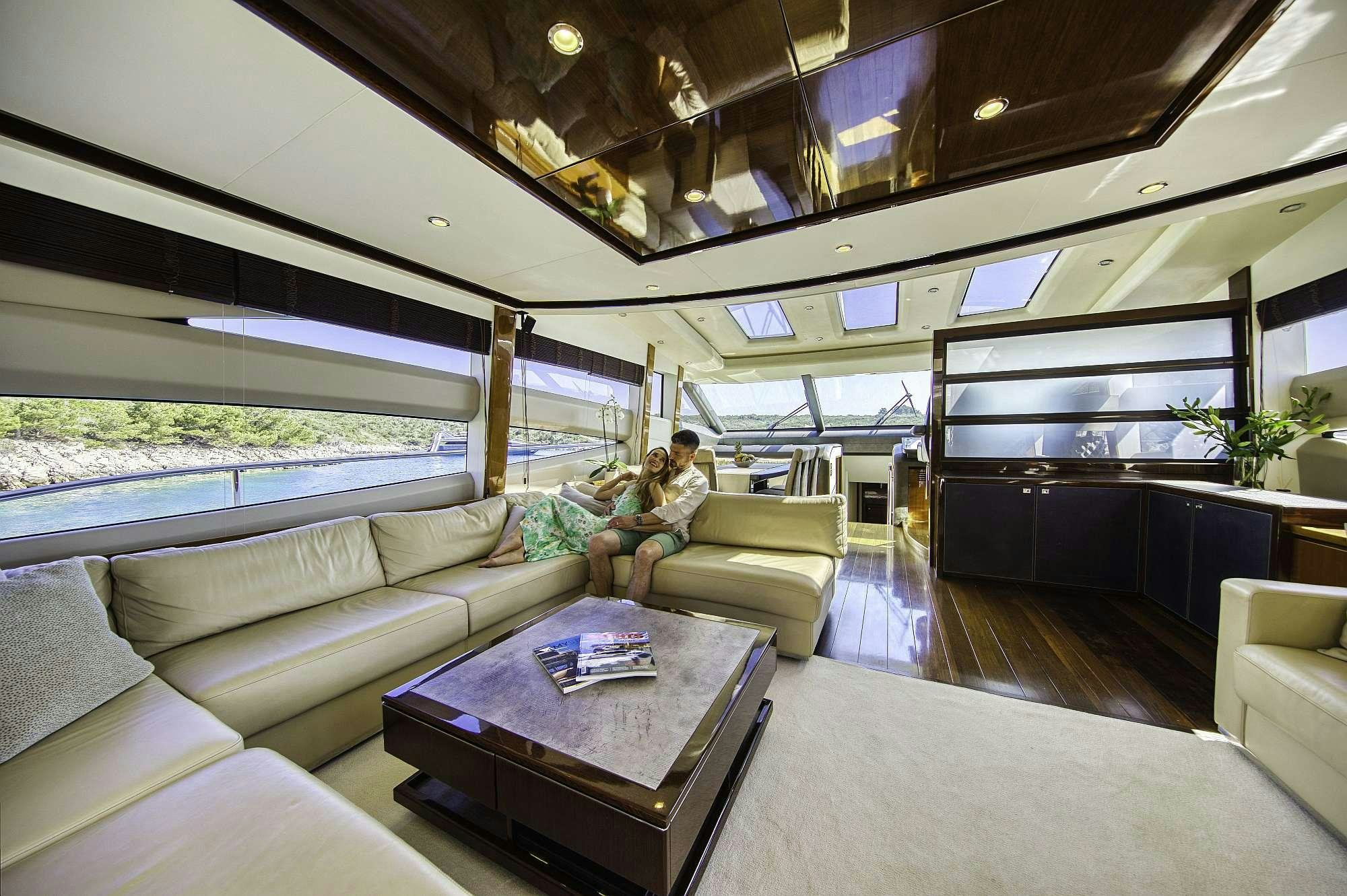 a person sitting on a couch in a room with a large window aboard AGAVE Yacht for Charter