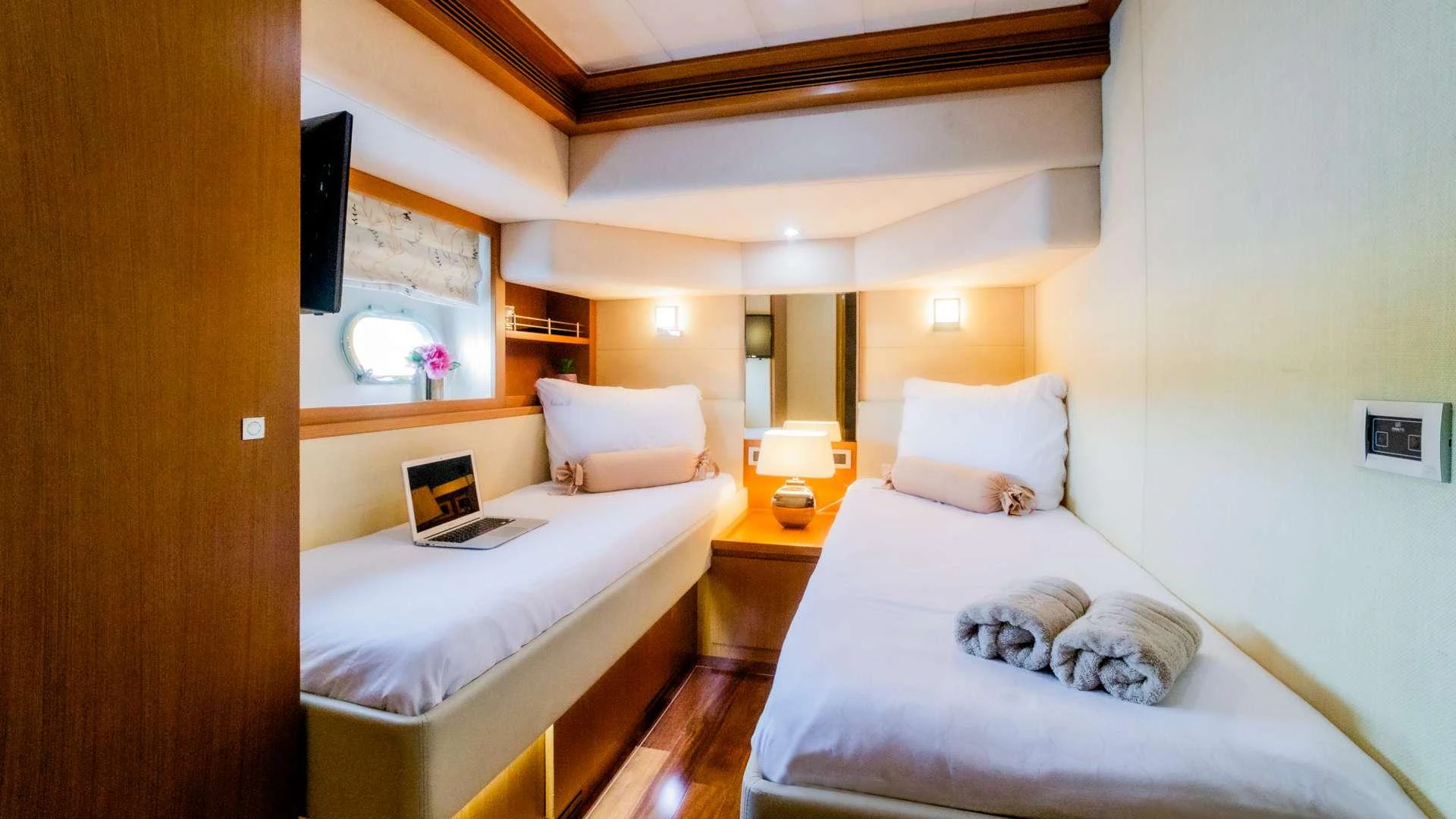 a bedroom with a bed and a laptop on the bed aboard ORLANDO L Yacht for Charter