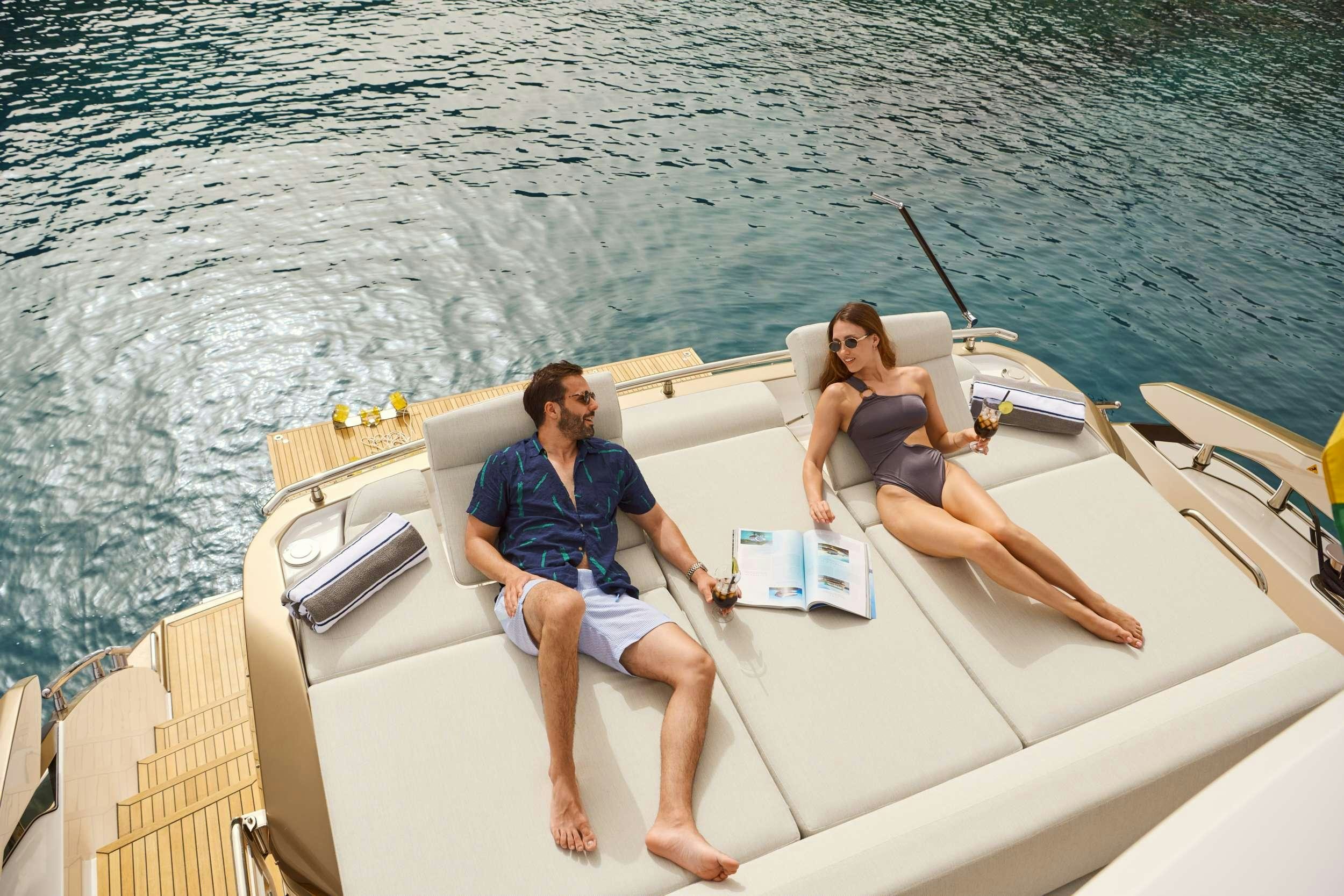 a man and woman sitting on a boat in the water aboard MYNE Yacht for Charter