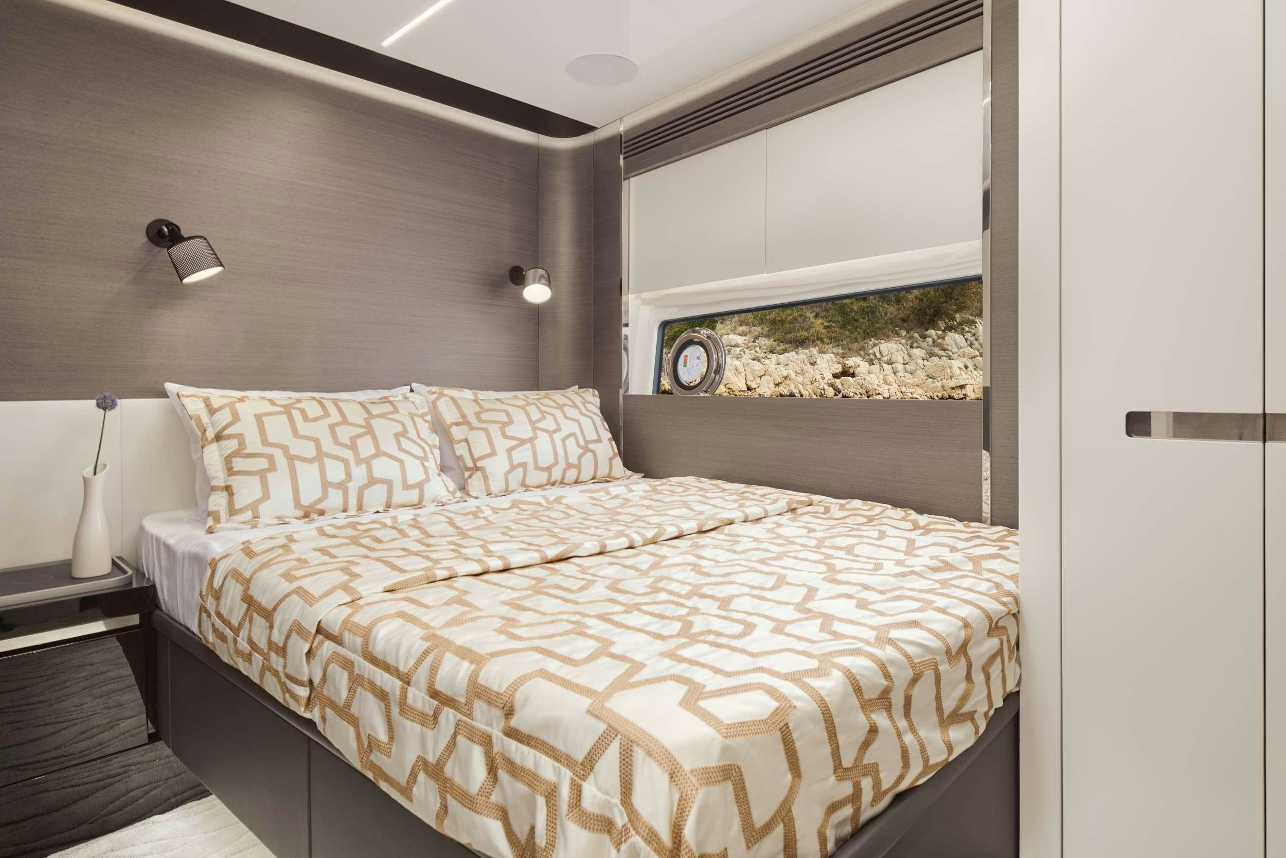 a bed with a large window aboard MYNE Yacht for Charter