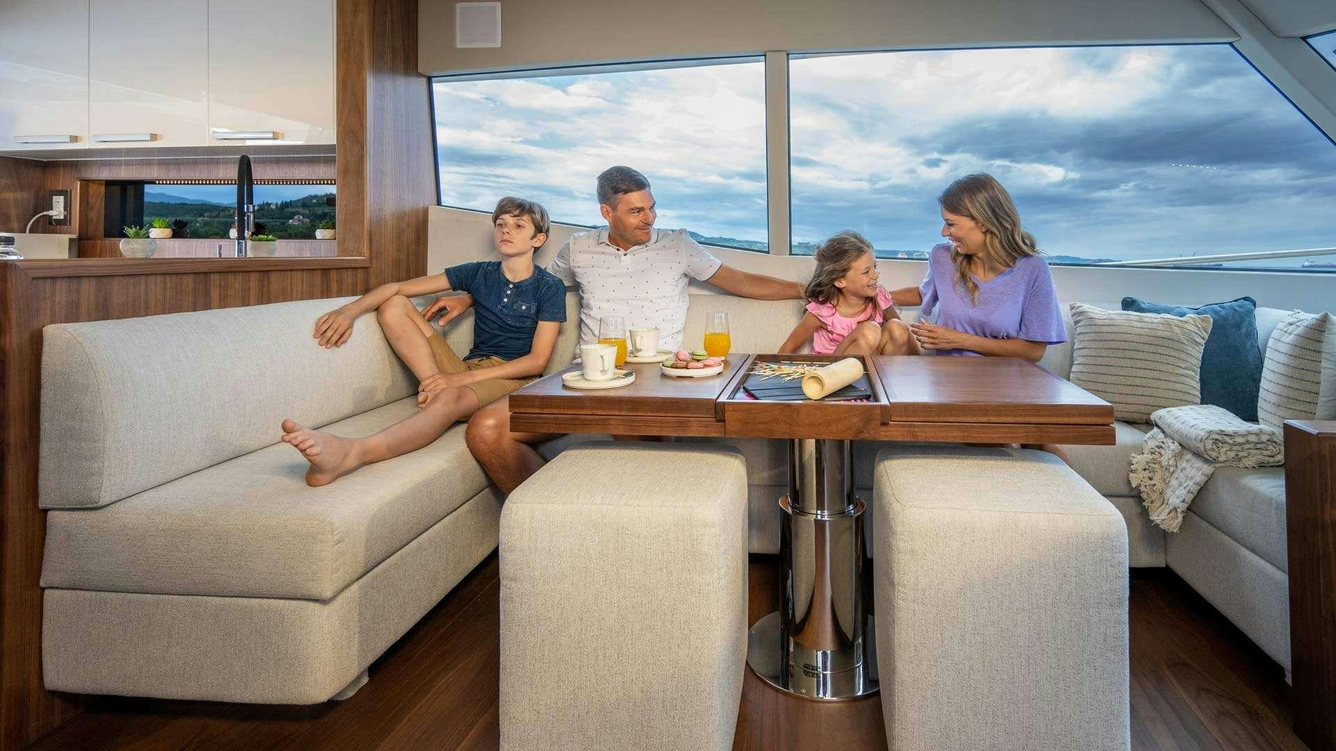 family sitting at a table aboard PANTA REI Yacht for Charter