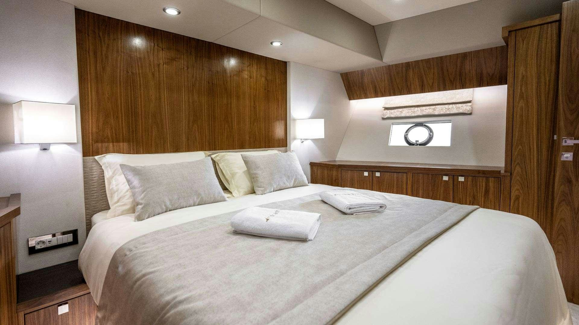 a bed with a white sheet and pillows aboard PANTA REI Yacht for Charter