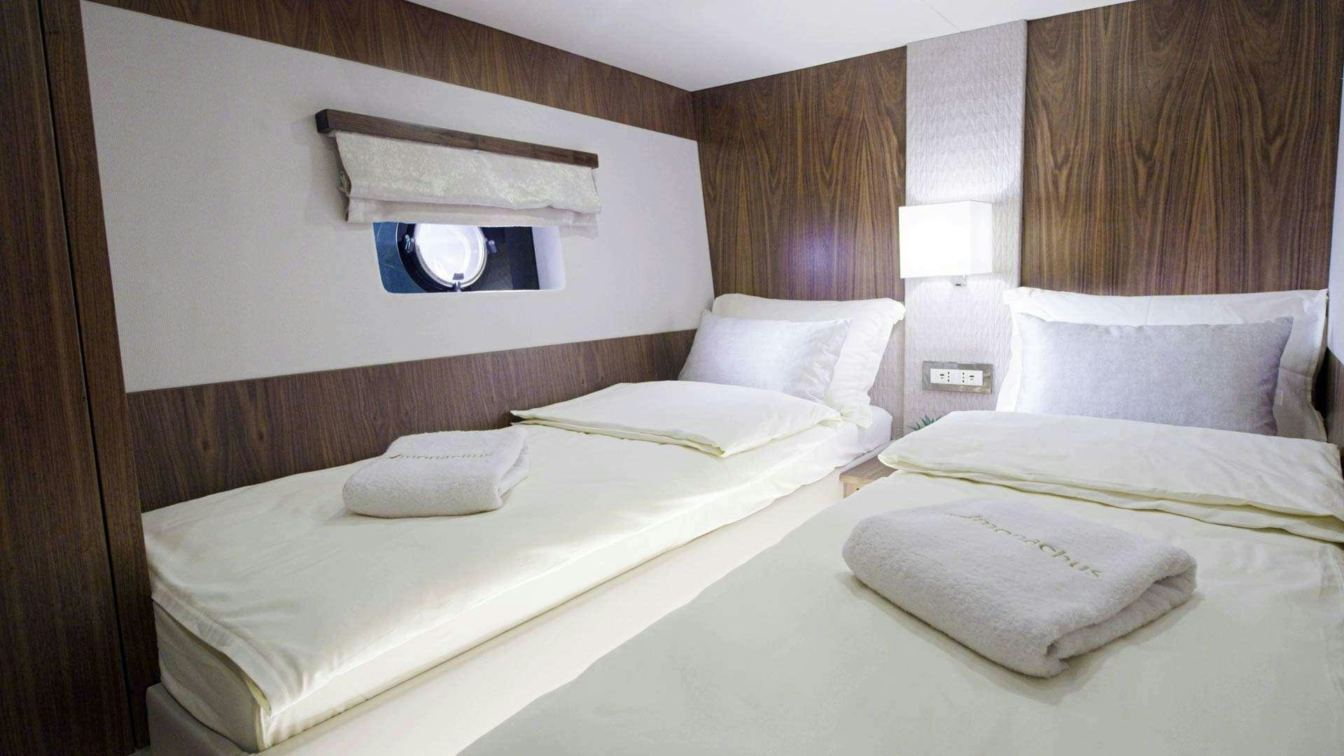 a room with beds and a mirror aboard PANTA REI Yacht for Charter
