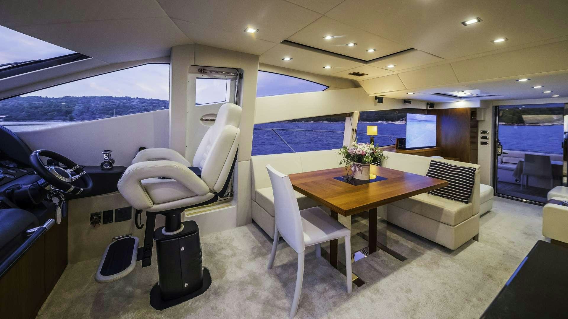 a room with a table chairs and a large window aboard 2 DRUNK Yacht for Charter