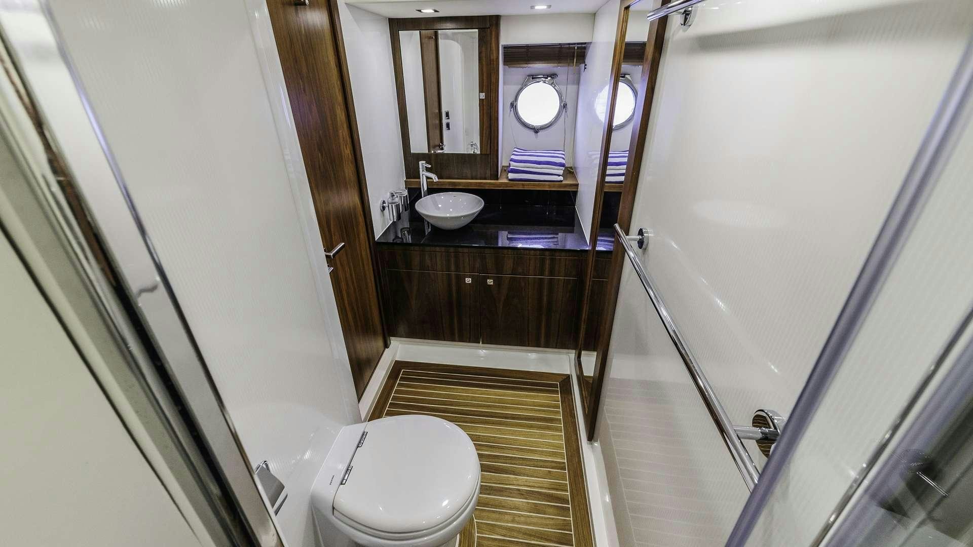 a bathroom with a sink toilet and a mirror aboard 2 DRUNK Yacht for Charter