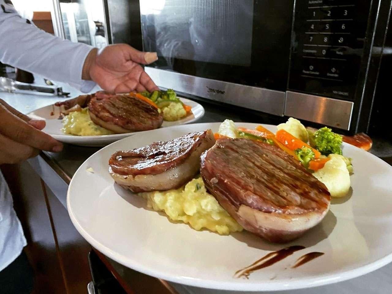 a person holding a plate of food aboard CAMY ED Yacht for Charter