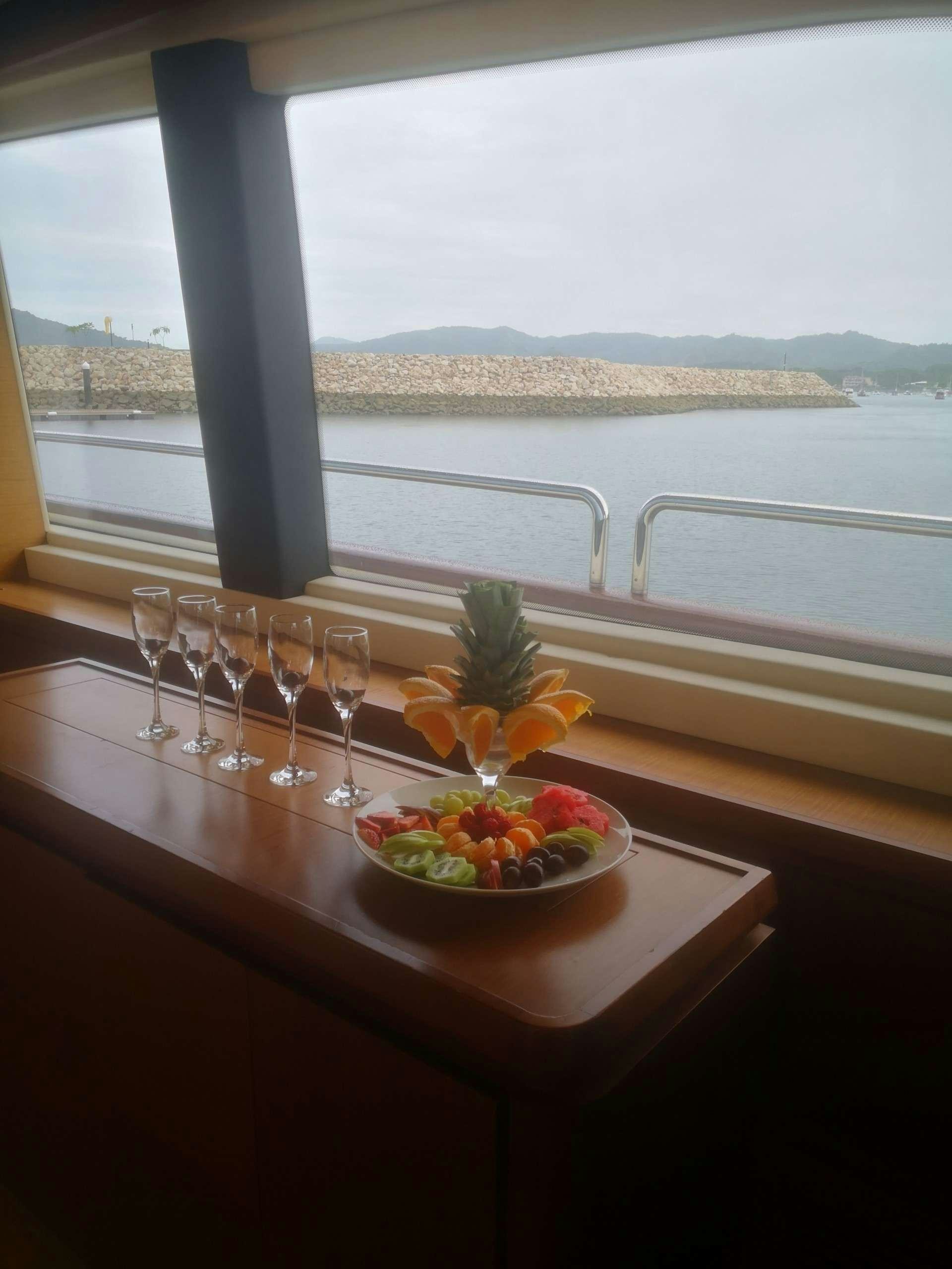 a table with wine glasses and fruit on it aboard CAMY ED Yacht for Charter