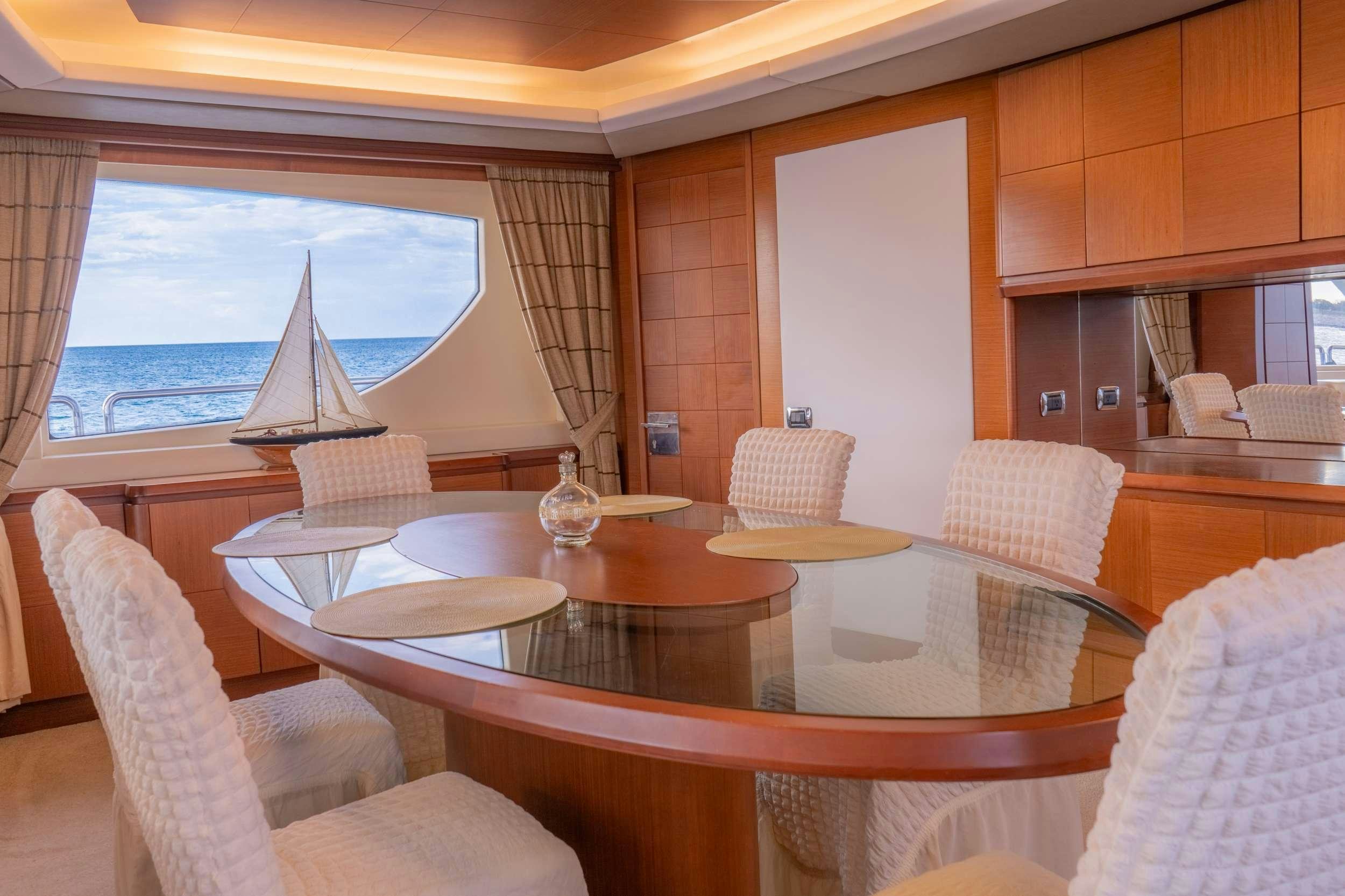 a dining table with chairs and a large umbrella aboard CAMY ED Yacht for Charter