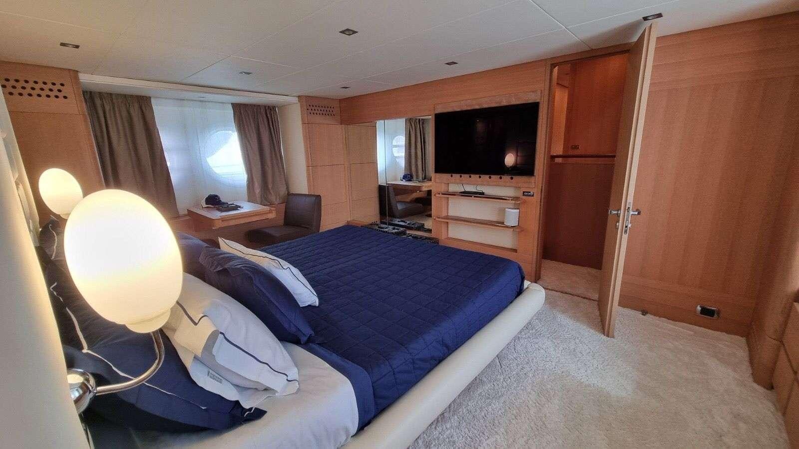 a room with a bed and a television aboard RED ROSE Yacht for Charter