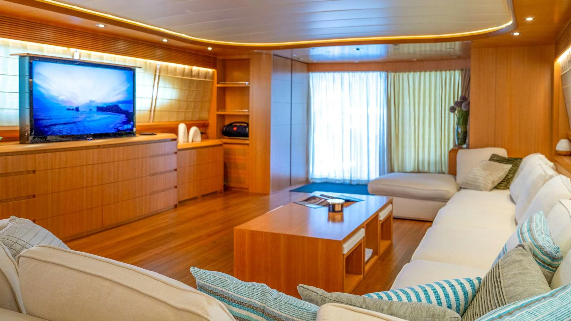 a living room with a tv and couches aboard CYNTHIA Yacht for Charter