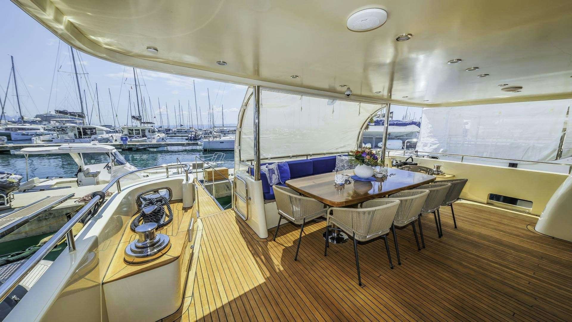 a large room with a table and chairs and a large window aboard GRACE Yacht for Charter