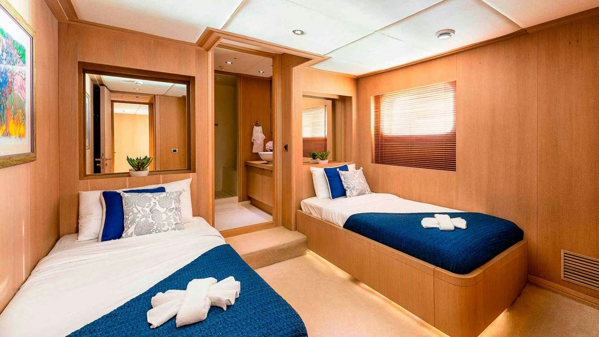 a room with beds and a mirror aboard GRACE Yacht for Charter