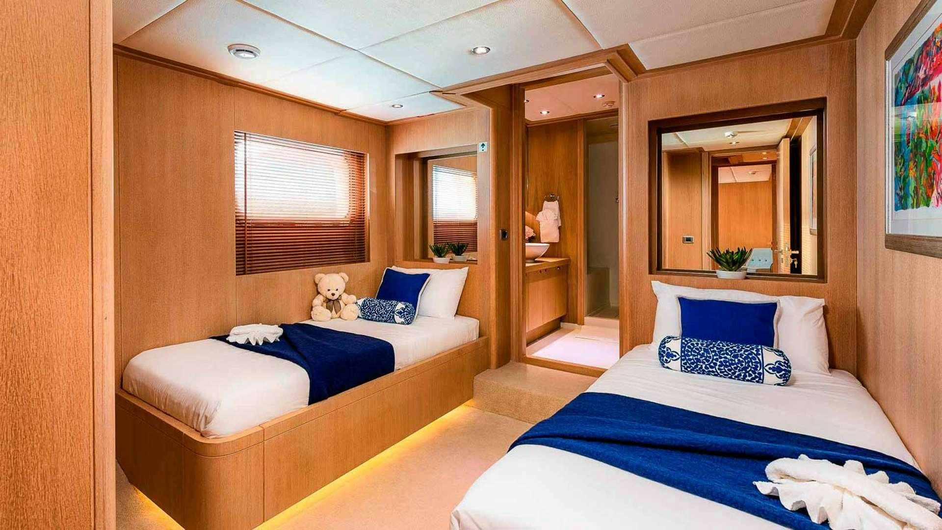 a room with beds and a mirror aboard GRACE Yacht for Charter