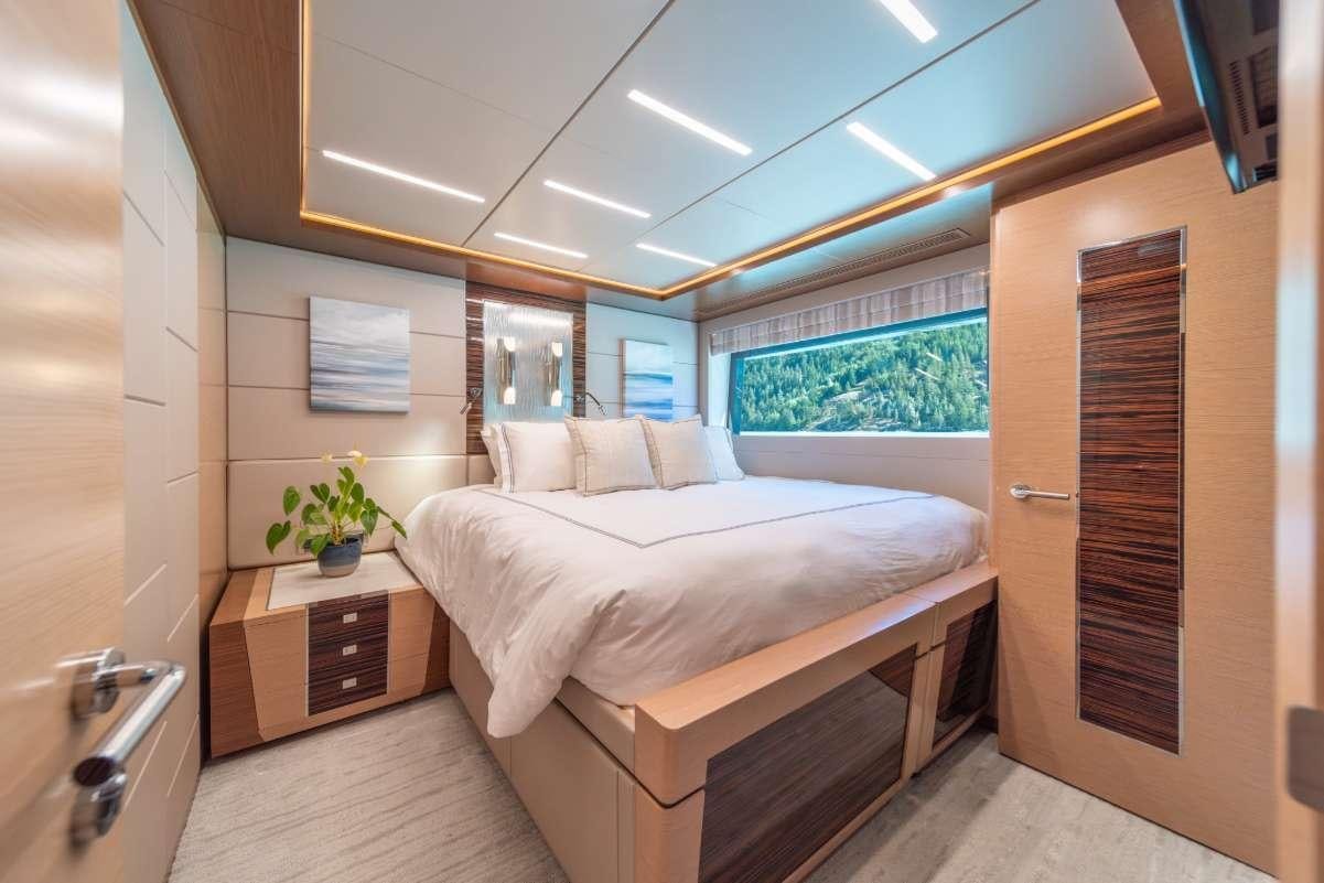 a bedroom with a bed and a window aboard VOYAGER Yacht for Charter