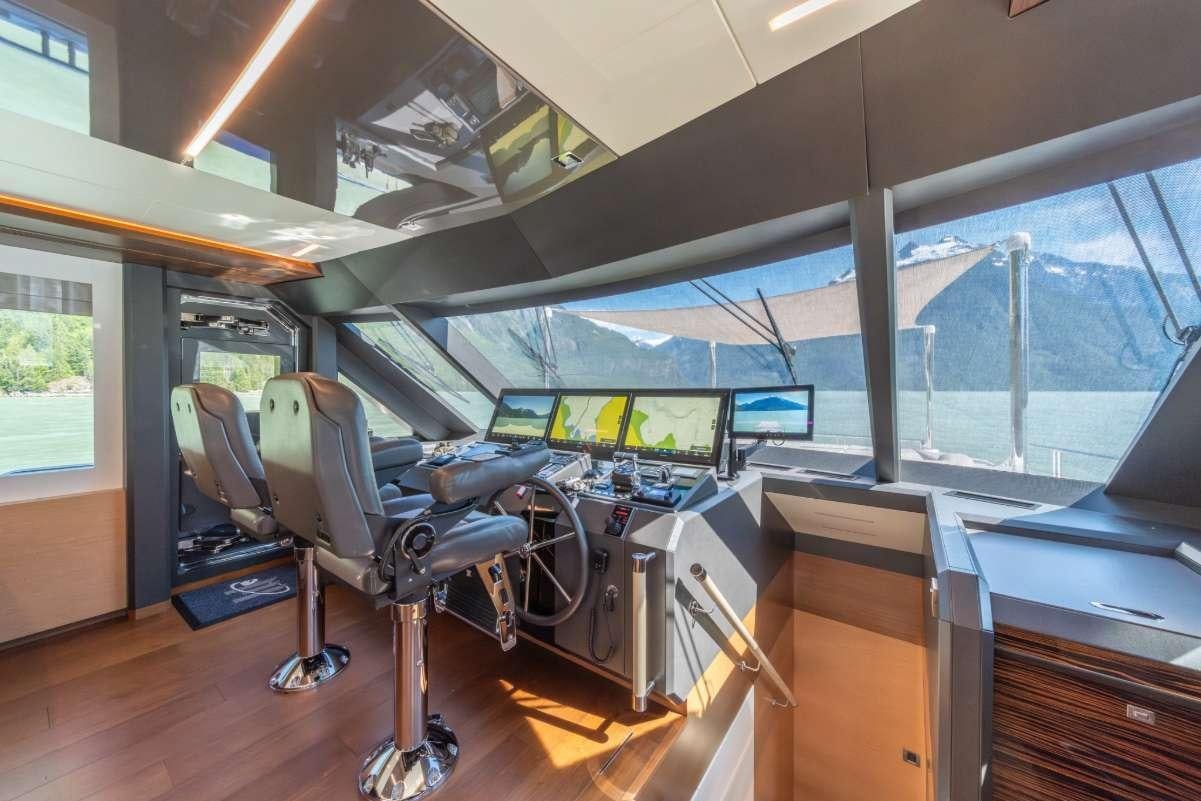 a room with a large window and a large desk with chairs and computers aboard VOYAGER Yacht for Charter
