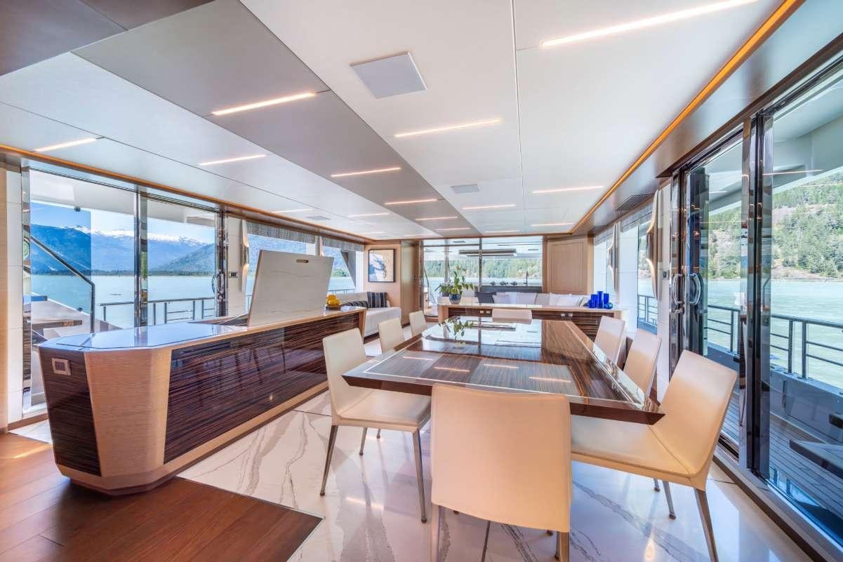 a room with a table chairs and a large window aboard VOYAGER Yacht for Charter