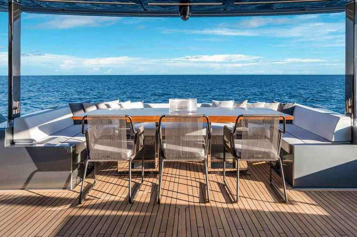 a table and chairs on a deck overlooking the ocean aboard BELLA DONNA Yacht for Charter