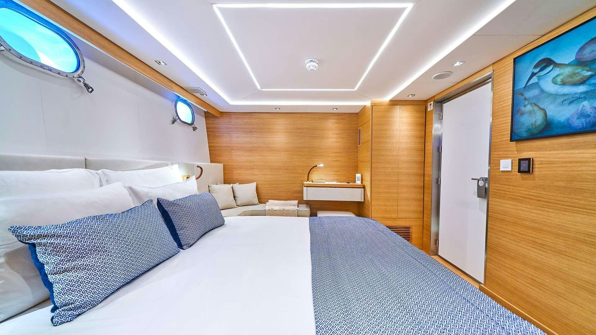 a room with a bed and a television aboard ARGO Yacht for Charter
