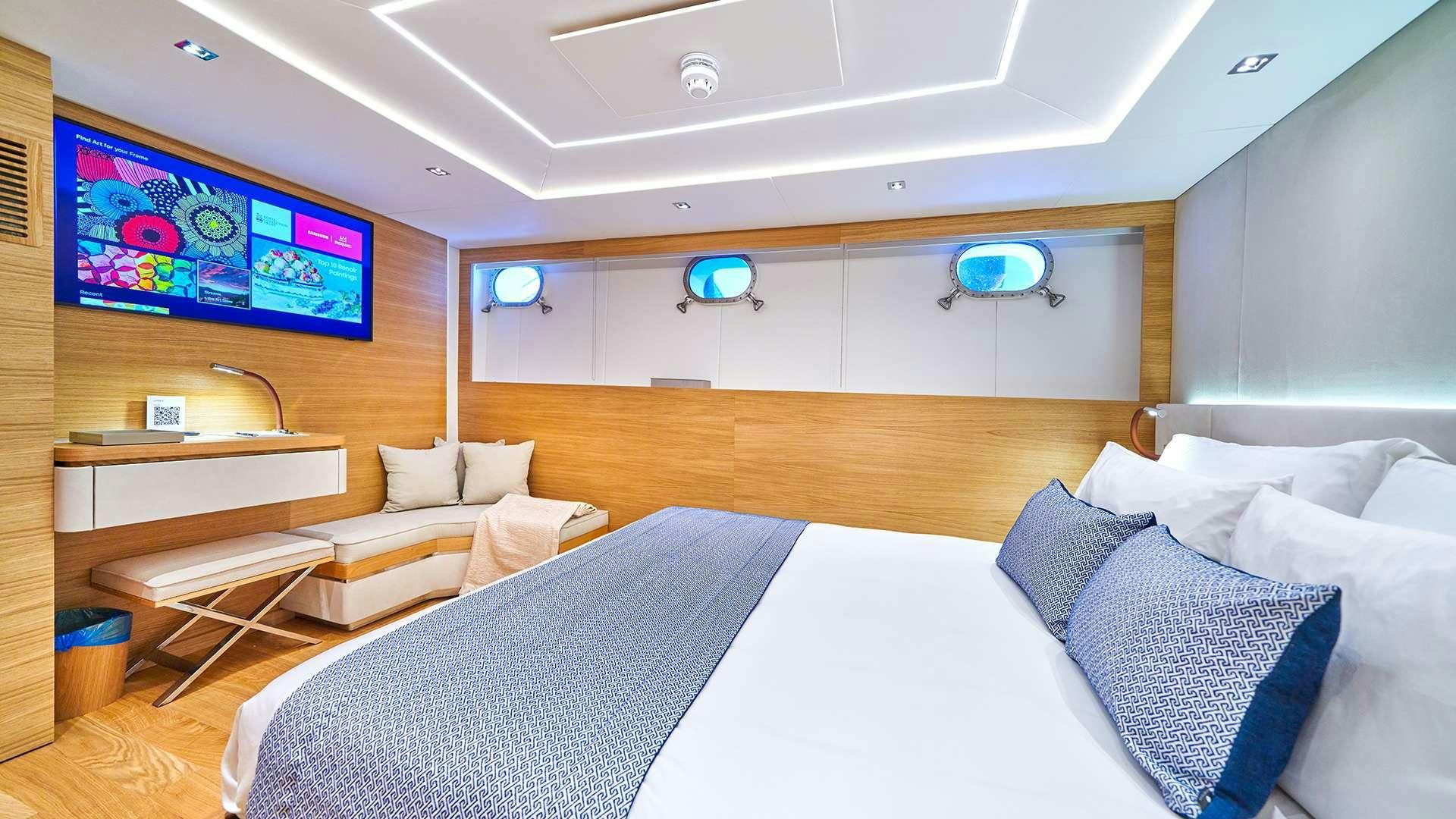 a room with a bed and a tv aboard ARGO Yacht for Charter