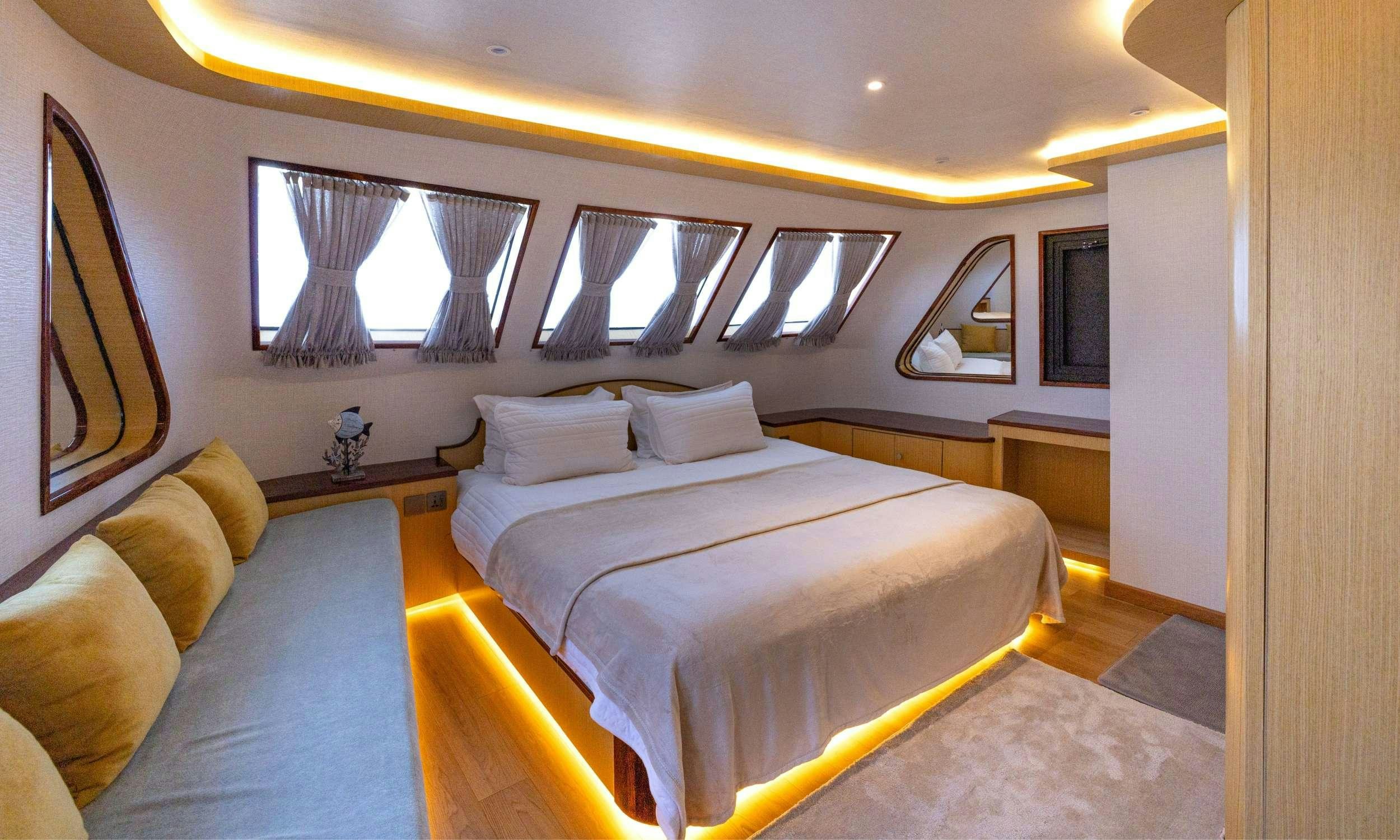 a bedroom with a bed and a couch aboard VISION Yacht for Charter