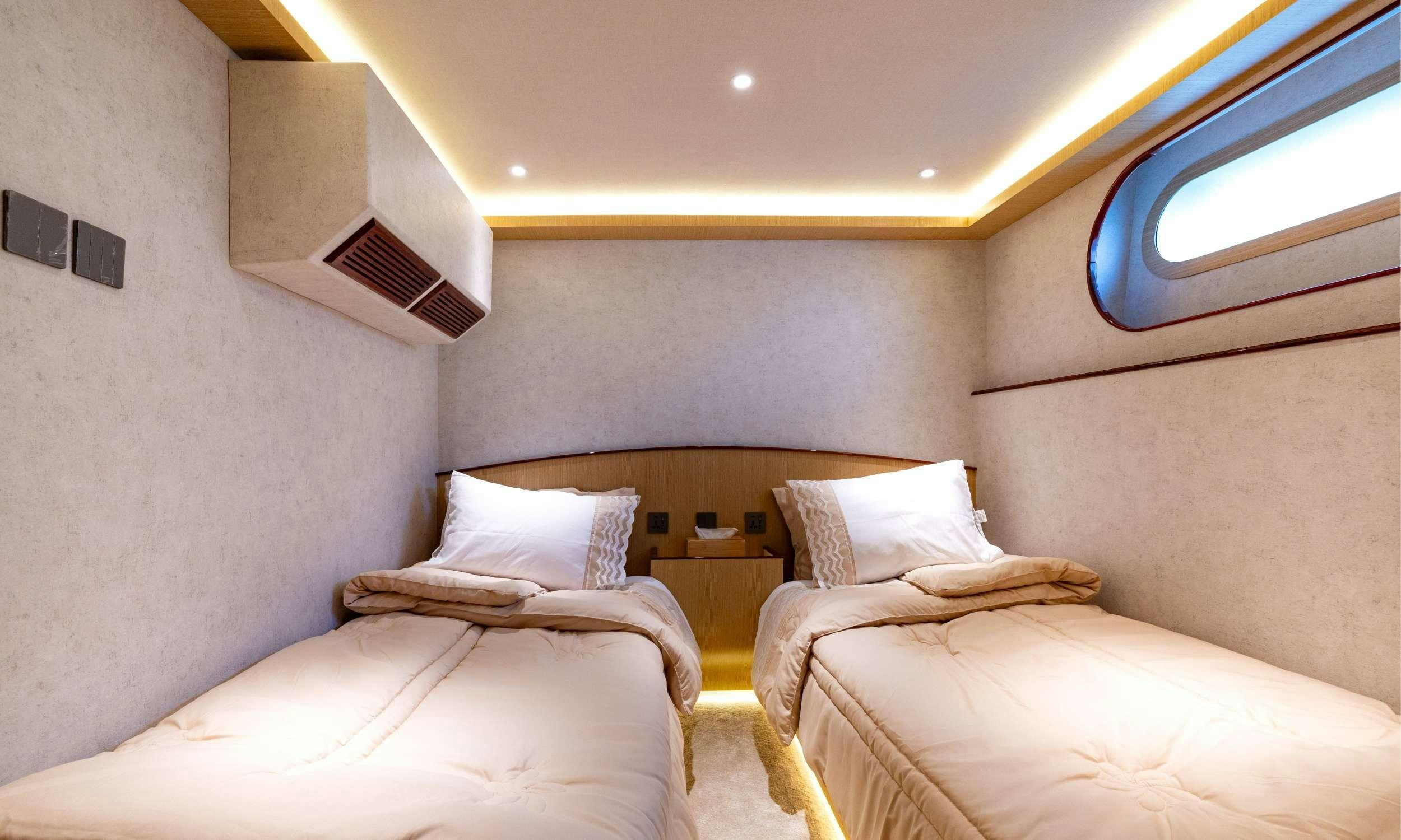 a room with beds and a window aboard VISION Yacht for Charter