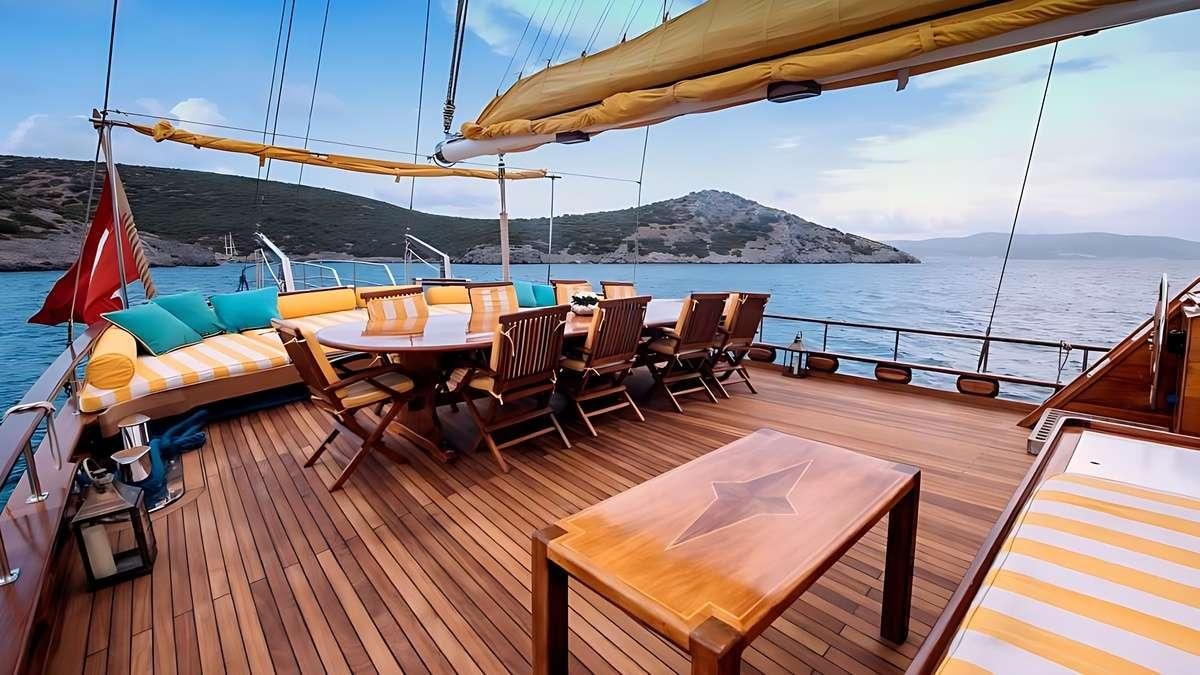 a deck with tables and chairs on it aboard PARSS Yacht for Charter