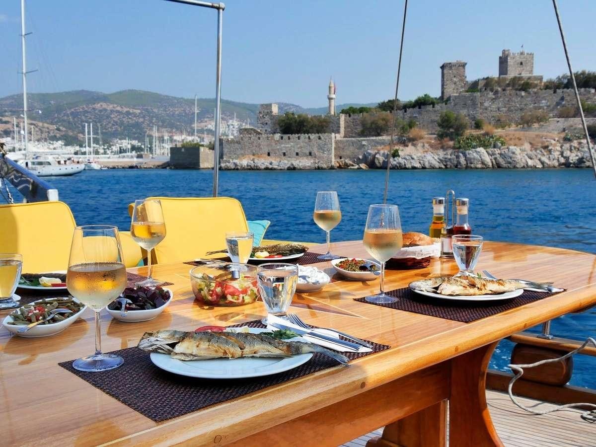 a table with food and wine glasses on it aboard PARSS Yacht for Charter