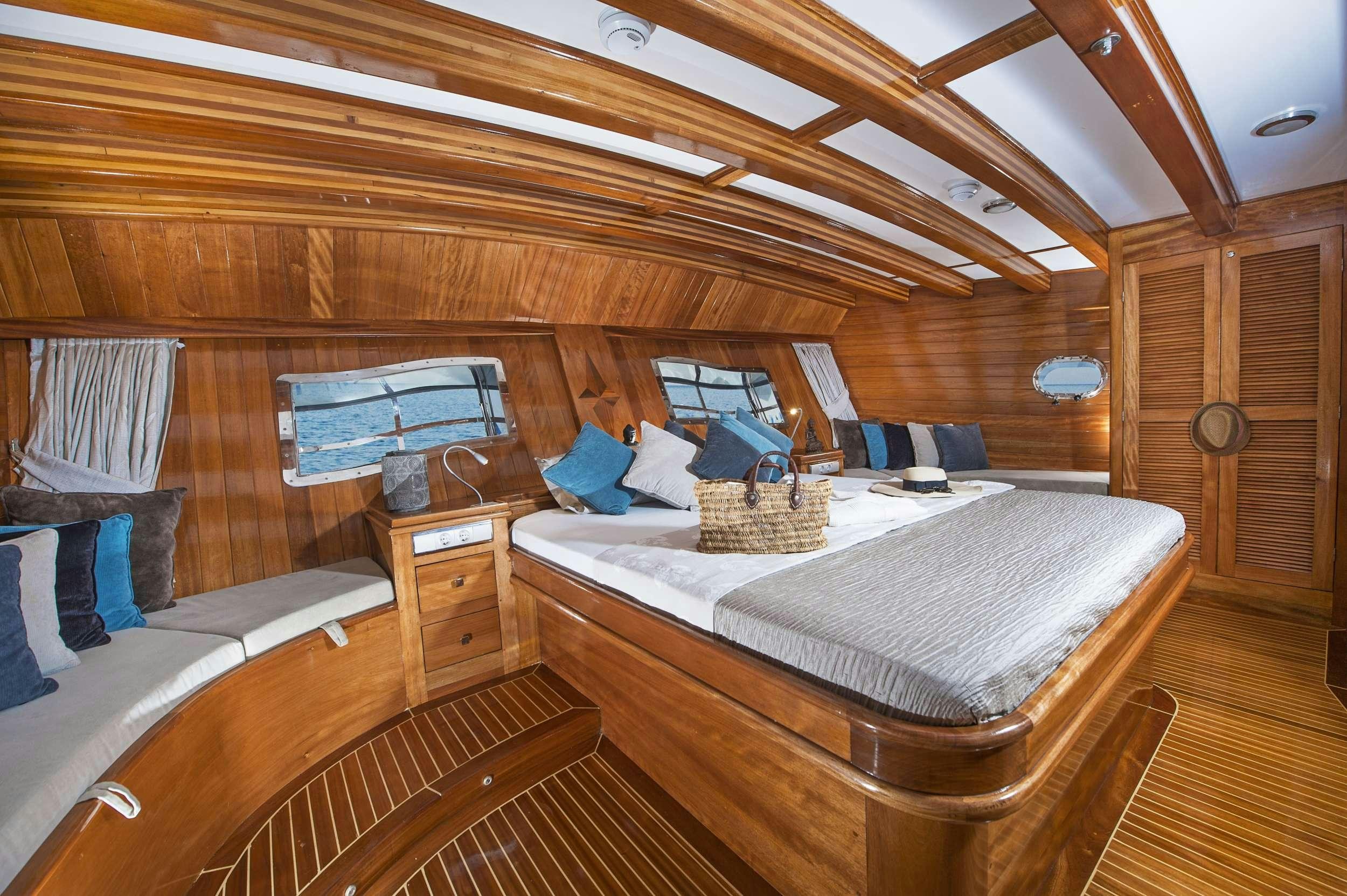 a room with a bed and a table aboard PARSS Yacht for Charter
