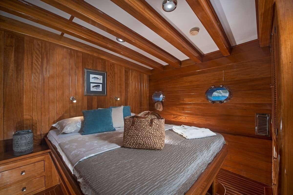 a bed with a round headboard and a round blue object on the side aboard PARSS Yacht for Charter
