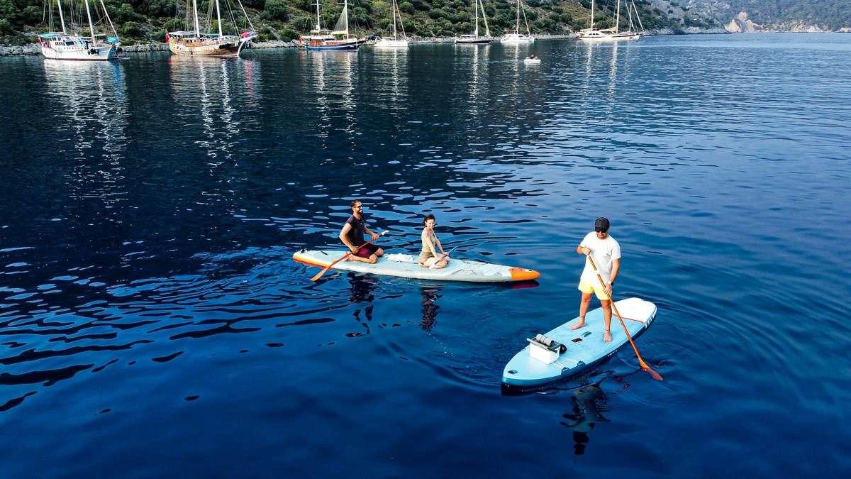 a group of people on surfboards in the water aboard FORTUNA Yacht for Charter