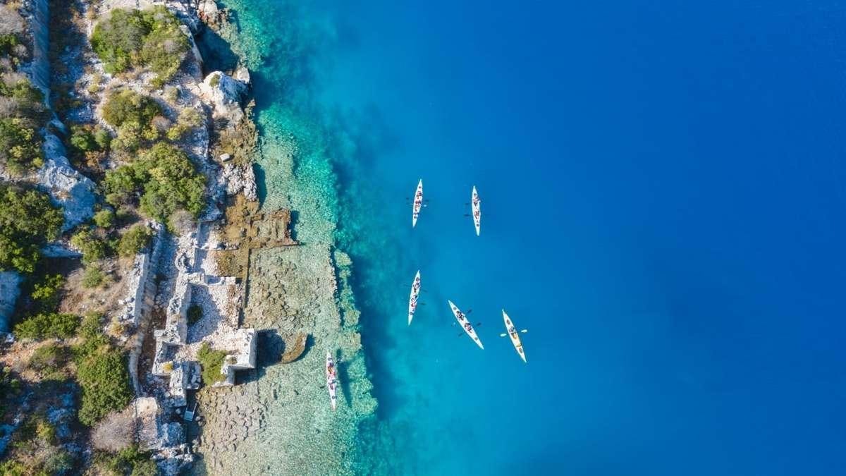 a group of airplanes flying over a rocky cliff aboard FORTUNA Yacht for Charter