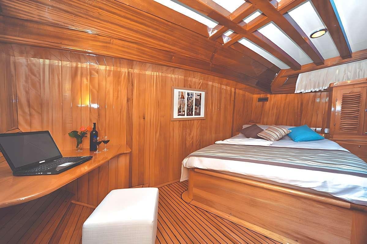 a bedroom with a laptop and a bed aboard FORTUNA Yacht for Charter