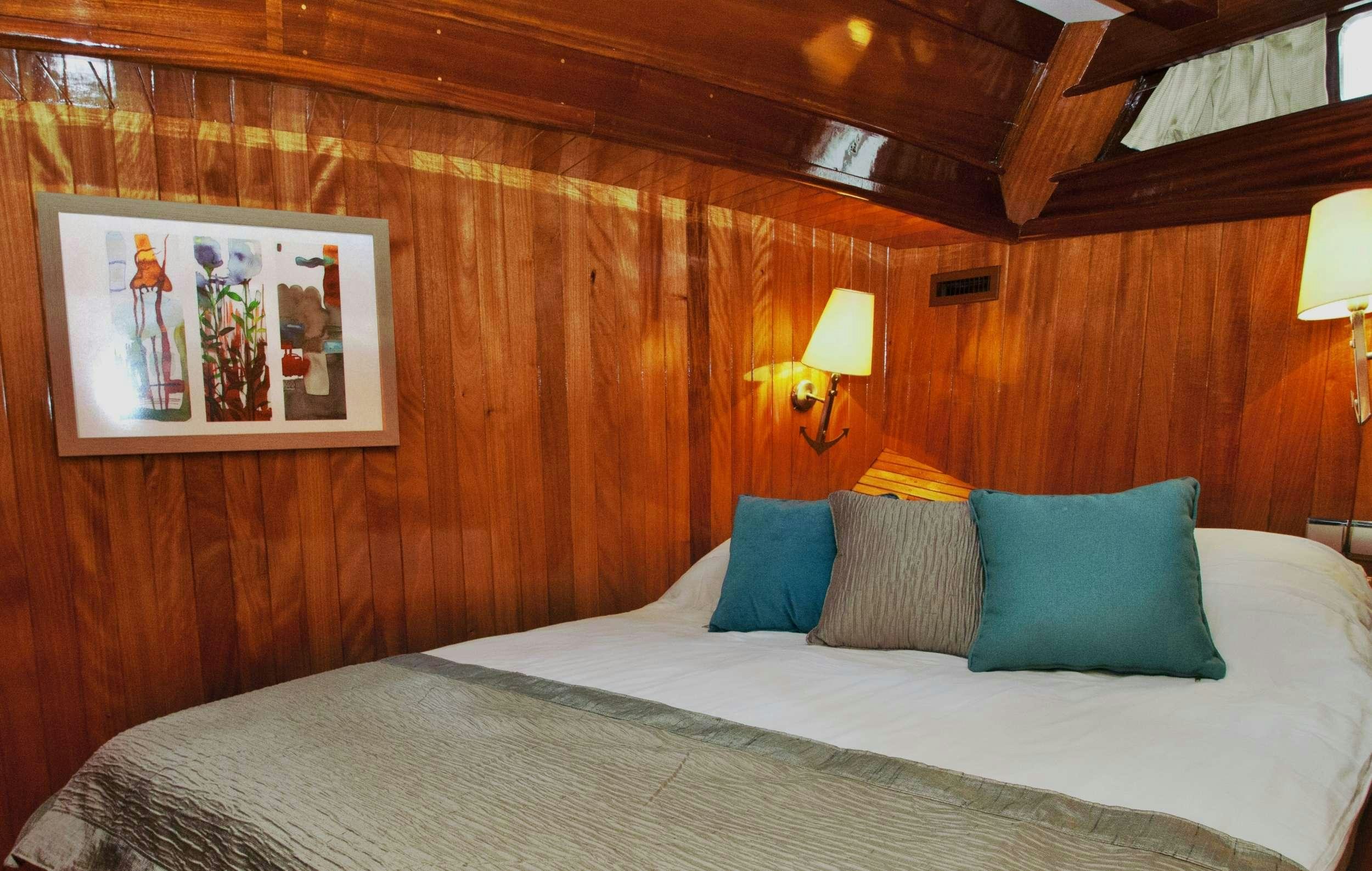 a bed with pillows and a lamp aboard FORTUNA Yacht for Charter