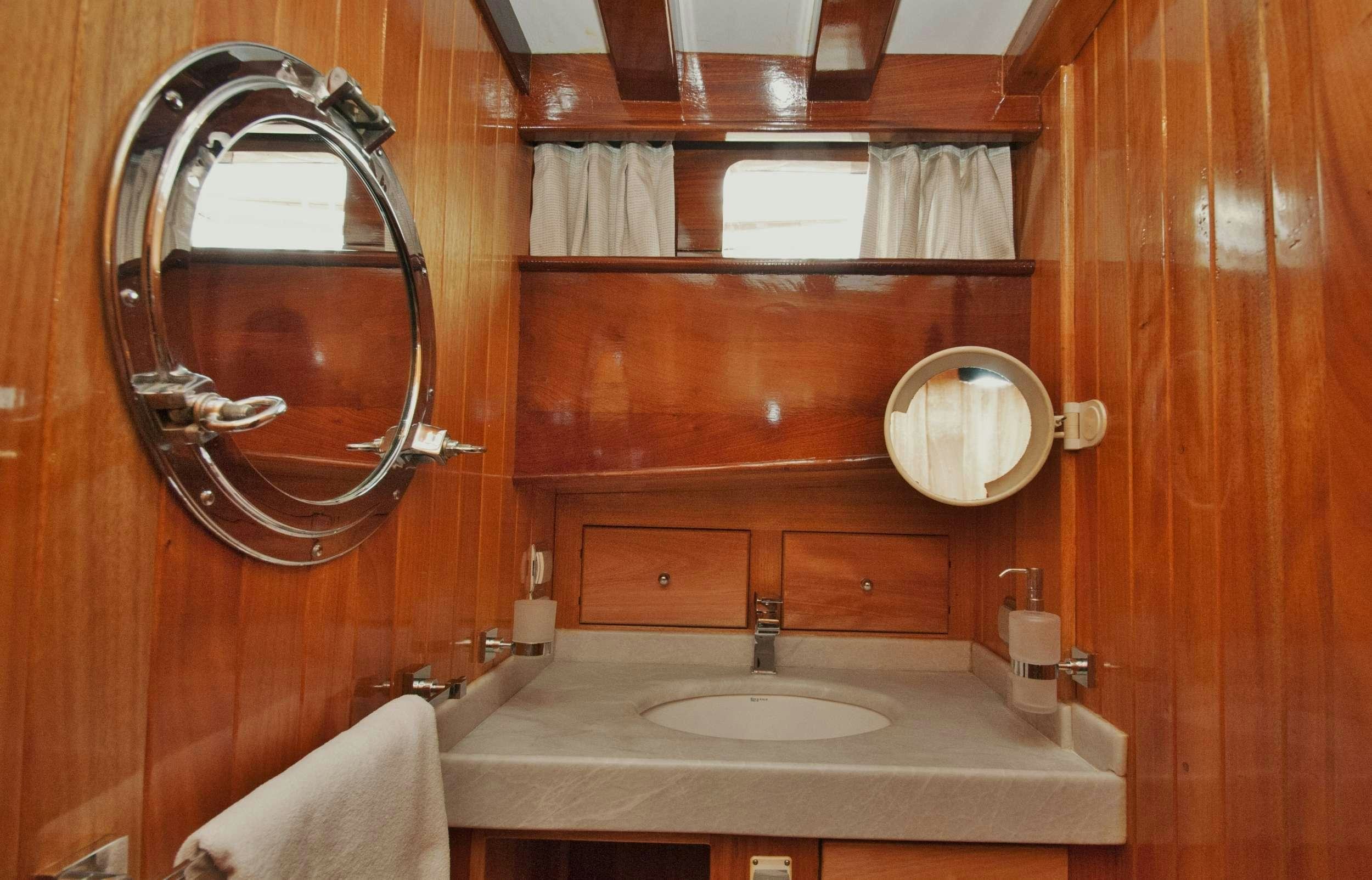 a bathroom with a mirror and a sink aboard FORTUNA Yacht for Charter
