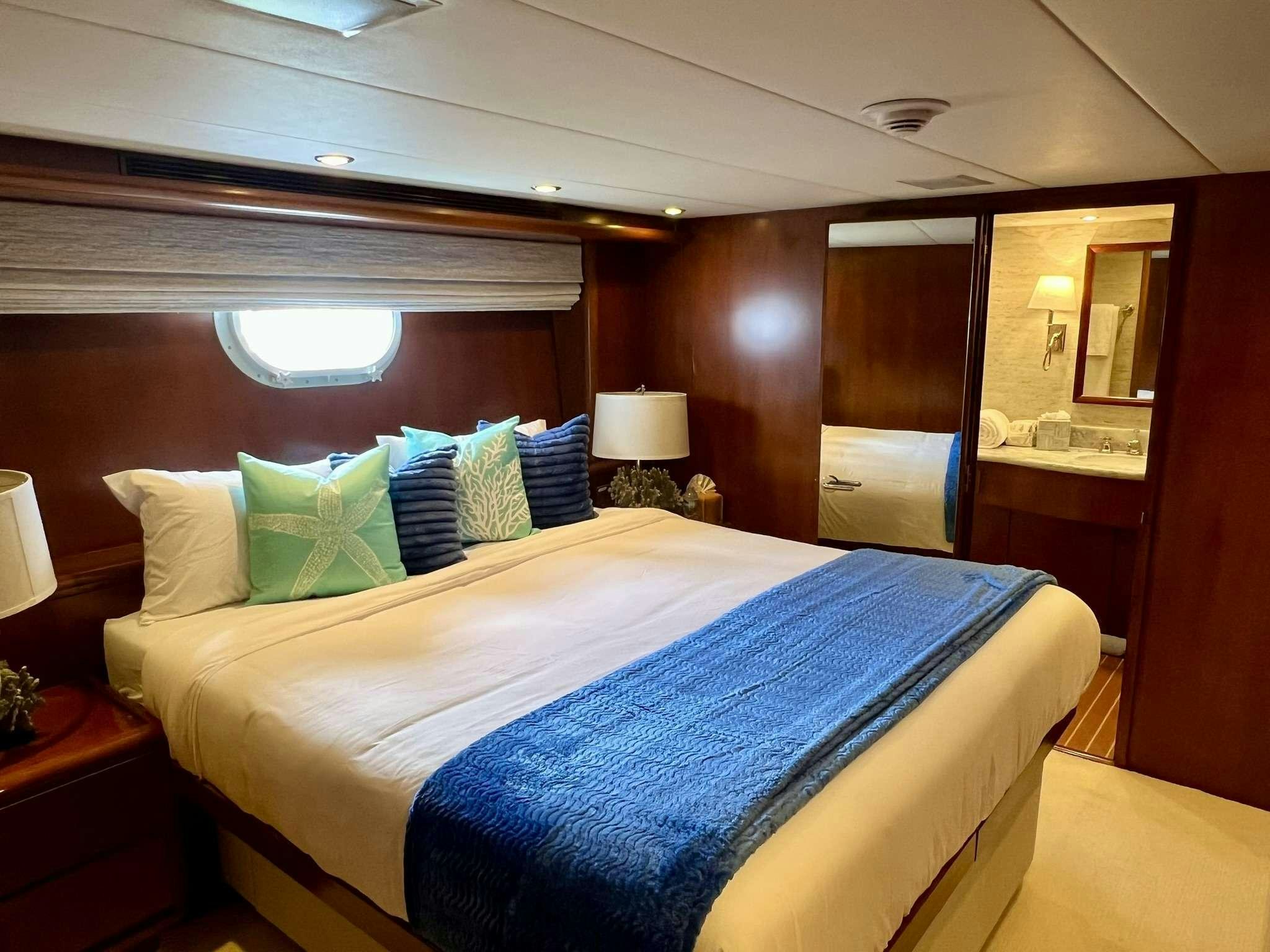 a bed with blue sheets aboard ESCAPE Yacht for Charter