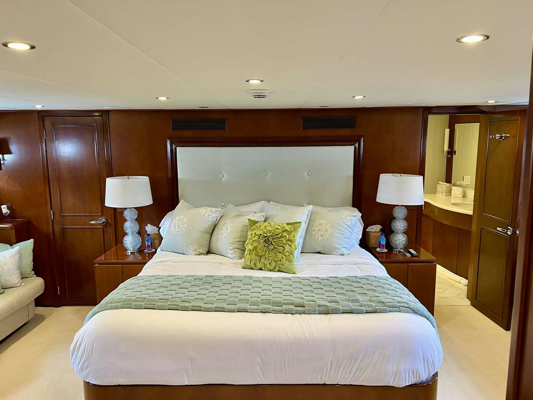 a hotel room with a bed and a lamp aboard ESCAPE Yacht for Charter