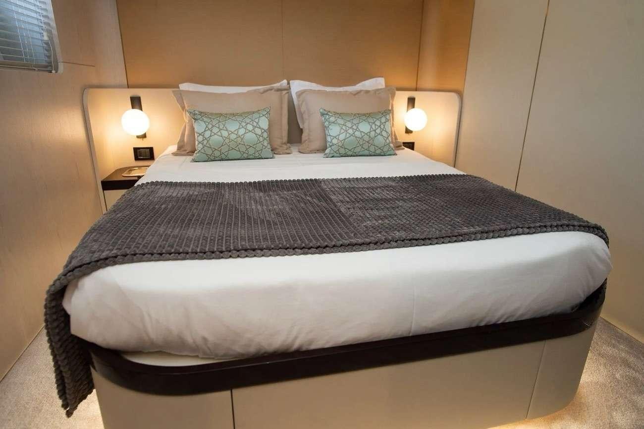 a bed with a black and white bed spread aboard PREWI Yacht for Charter