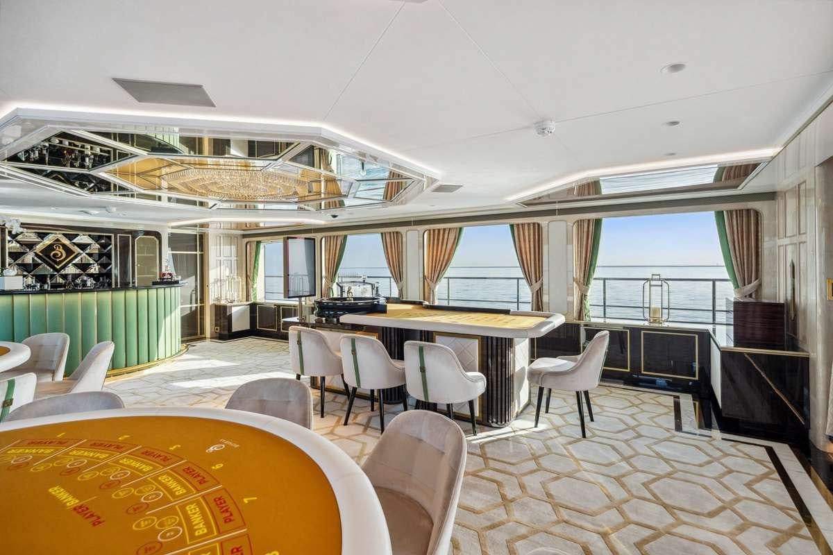 a room with tables and chairs aboard BOMBAY Yacht for Charter