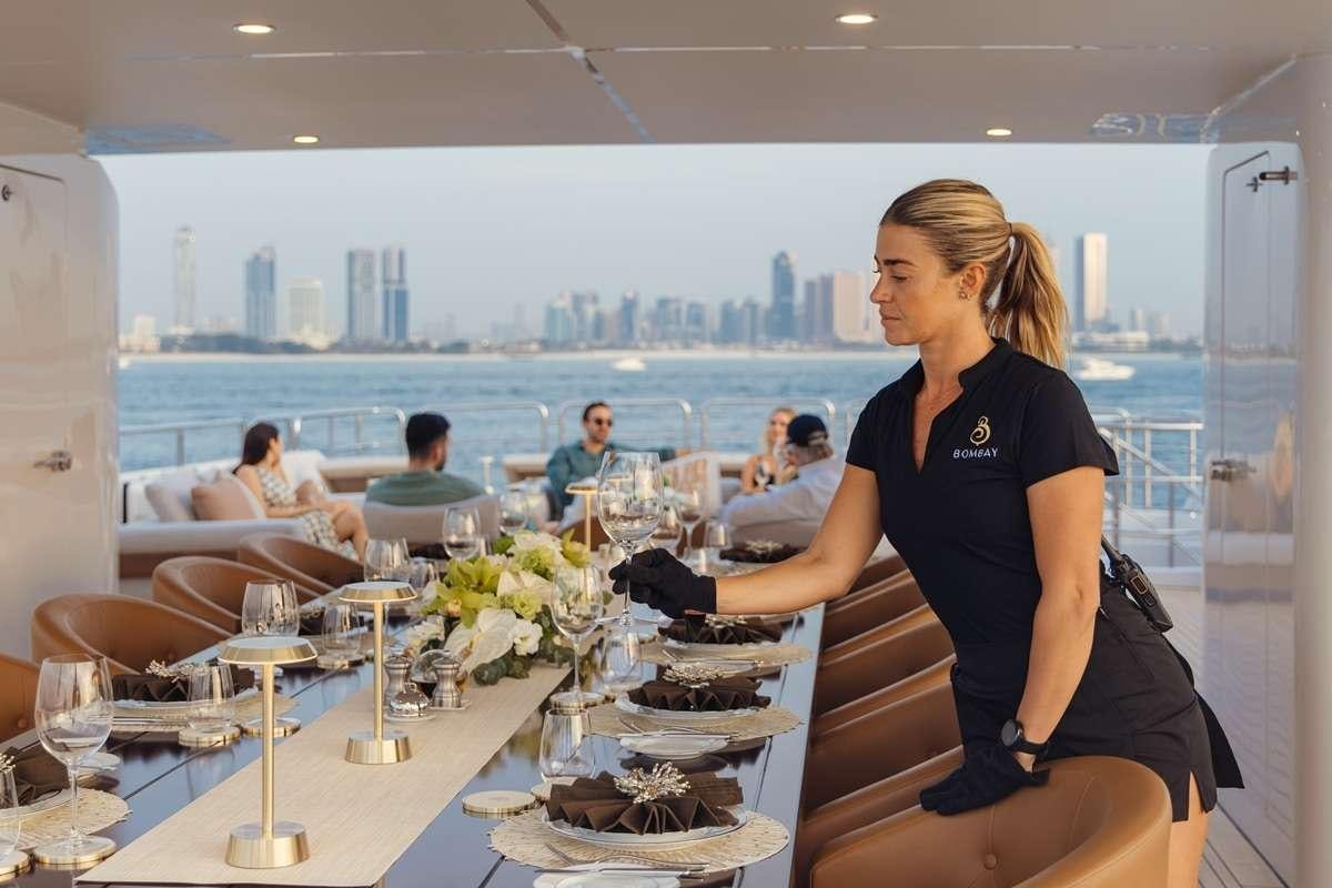 a woman standing in a restaurant aboard BOMBAY Yacht for Charter