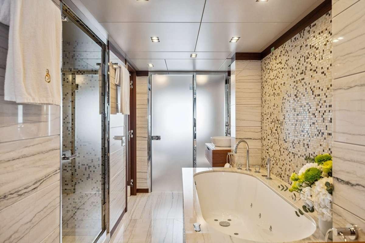 a bathroom with a bathtub and shower aboard BOMBAY Yacht for Charter