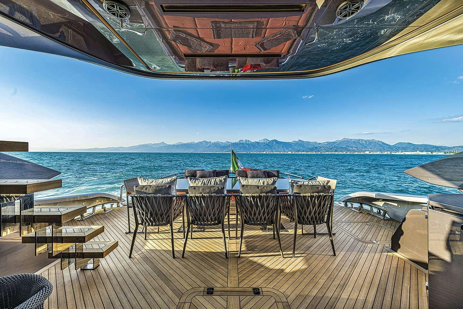 a table and chairs on a deck overlooking a large body of water aboard G-FIVE Yacht for Charter
