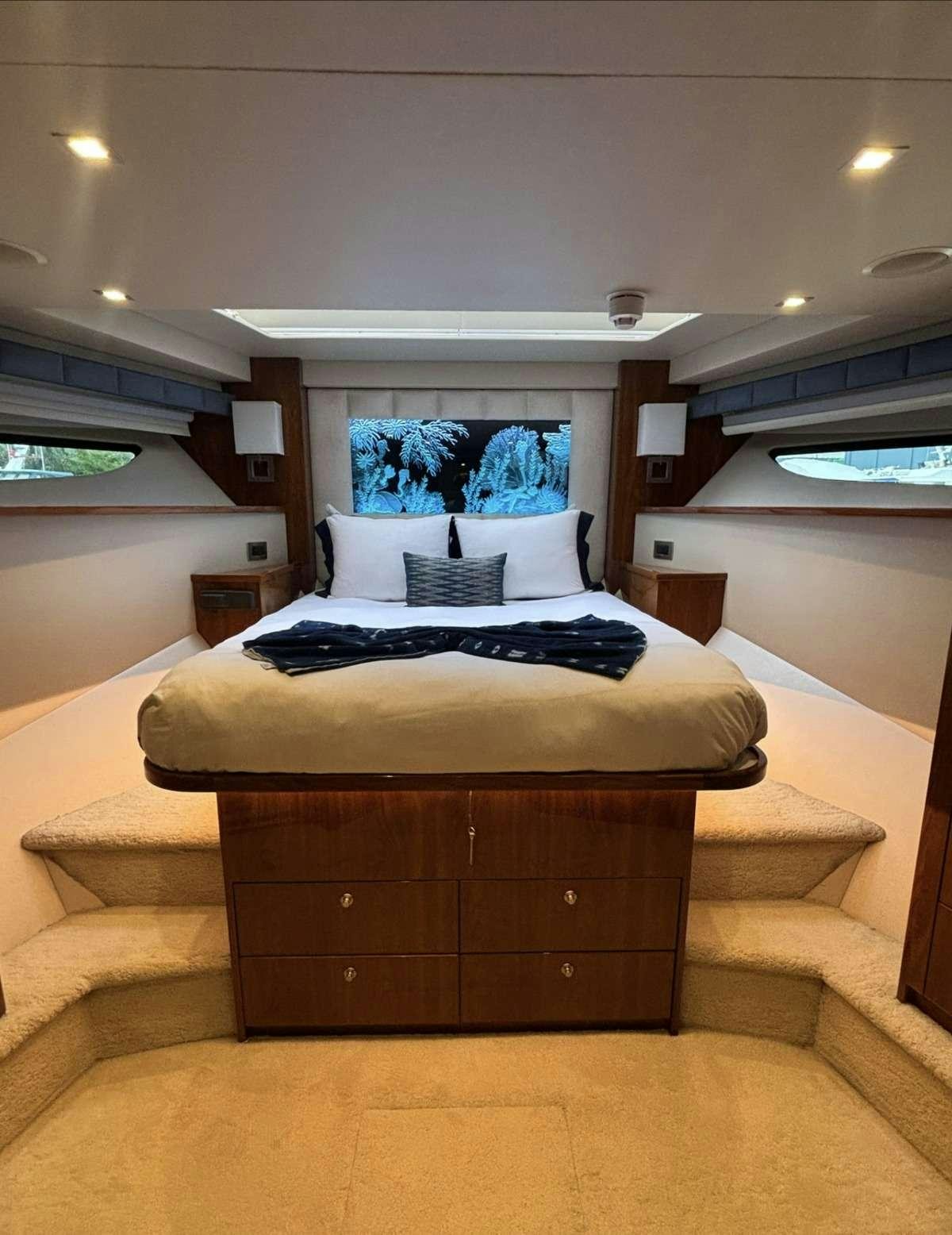 a bed with a large wooden dresser aboard INDIGO Yacht for Charter