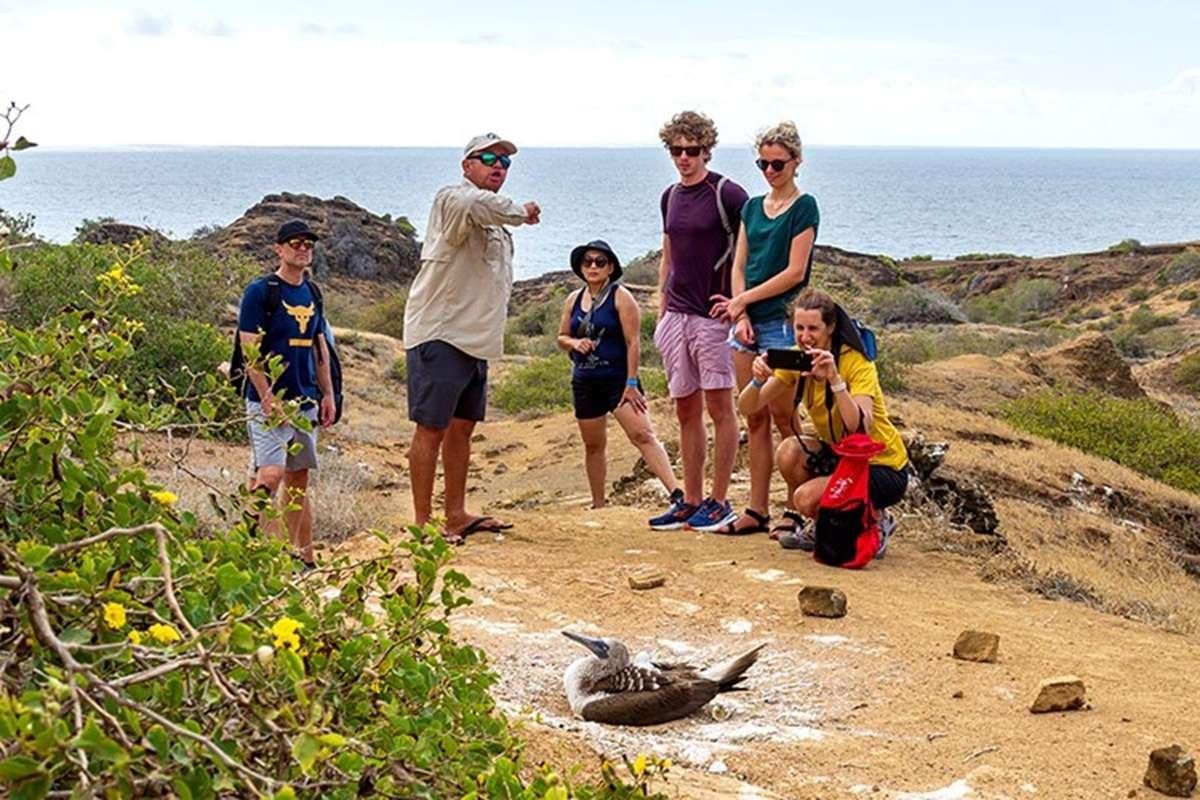 a group of people standing on a beach aboard GALAPAGOS ANGEL Yacht for Charter