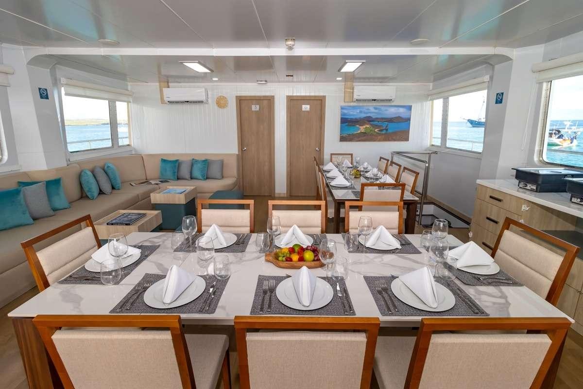 a dining room with tables and chairs aboard GALAPAGOS ANGEL Yacht for Charter