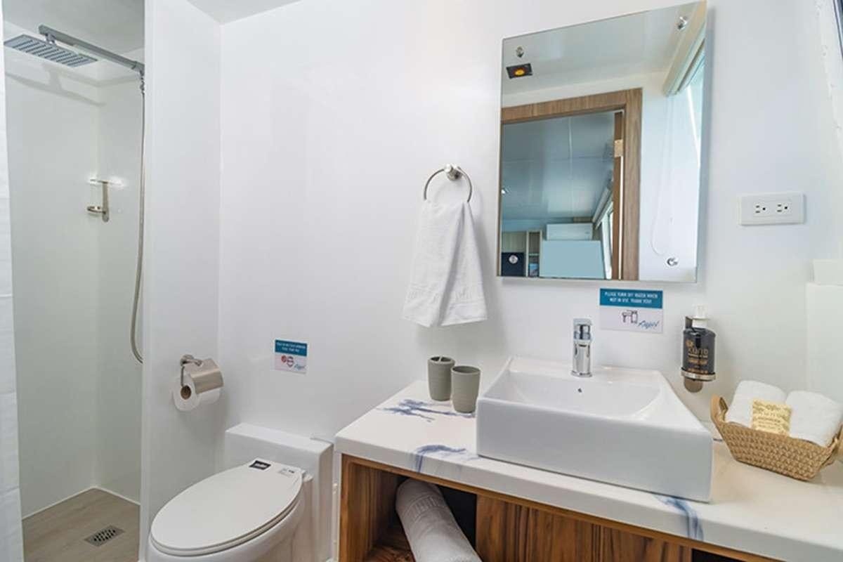 a bathroom with a sink and mirror aboard GALAPAGOS ANGEL Yacht for Charter