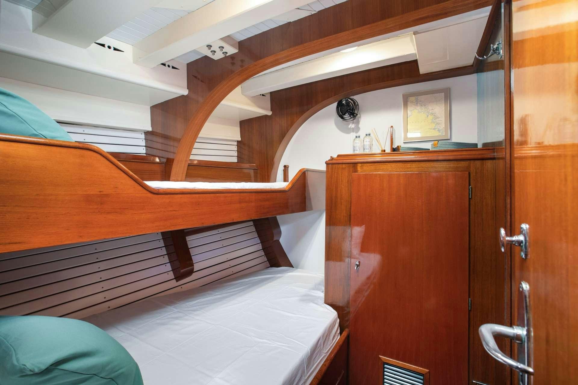 a bed with a wooden headboard aboard GAEL I Yacht for Charter